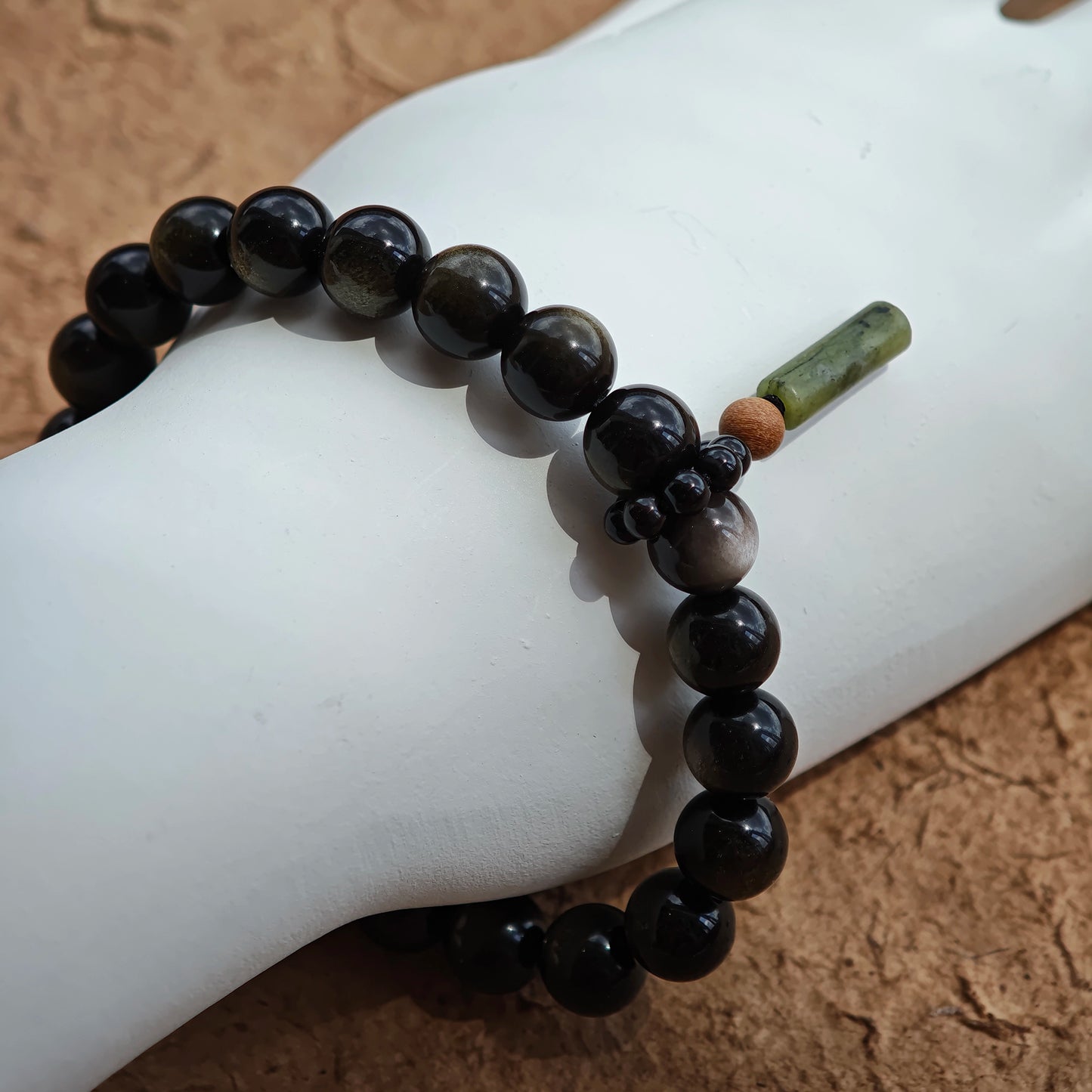 Gold and silver obsidian unite for strength, while rutile and a carved sandalwood-agate charm whisper ancient China.