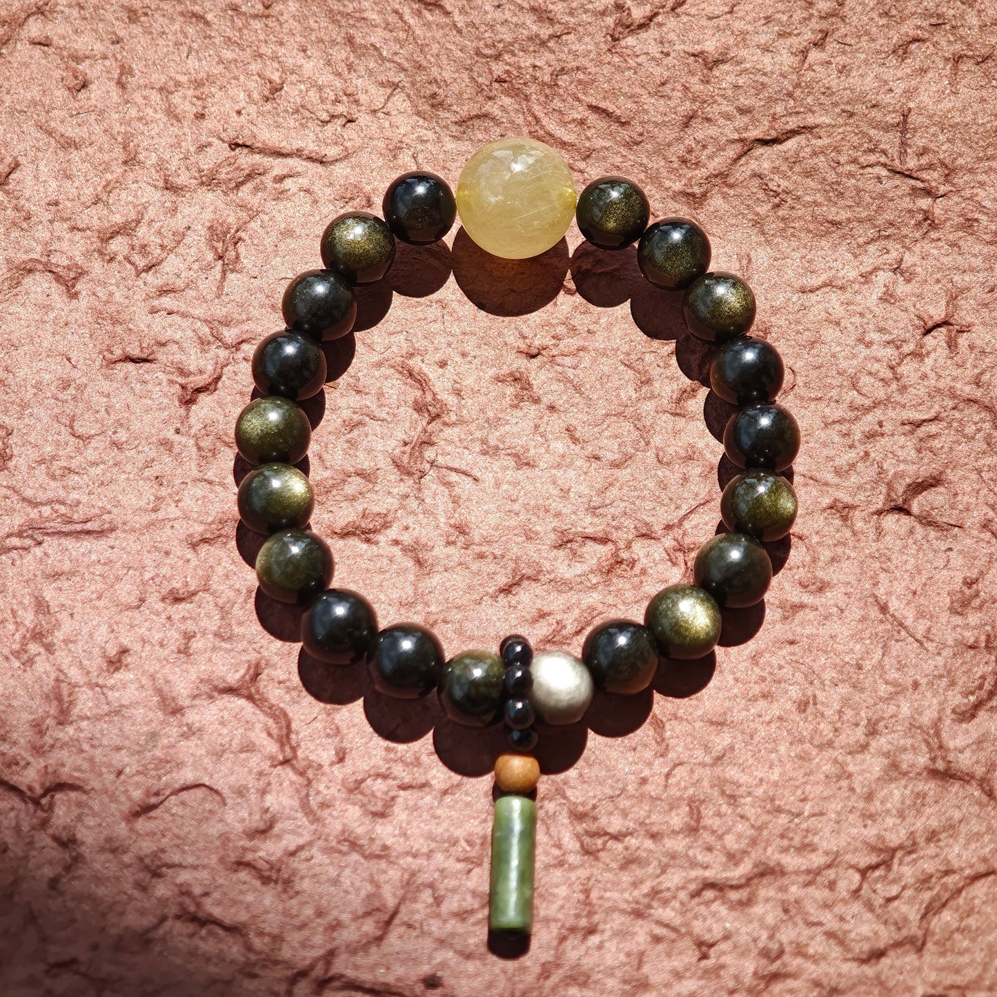 Wrap your wrist in obsidian’s dual flash, rutile’s sparkle, and a sandalwood-agate story from the East.