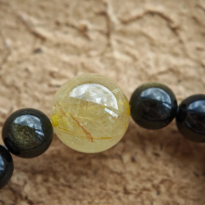 Eastern serenity meets Western polish: dual-sheen obsidian, rutile accent, and a wood-agate charm.