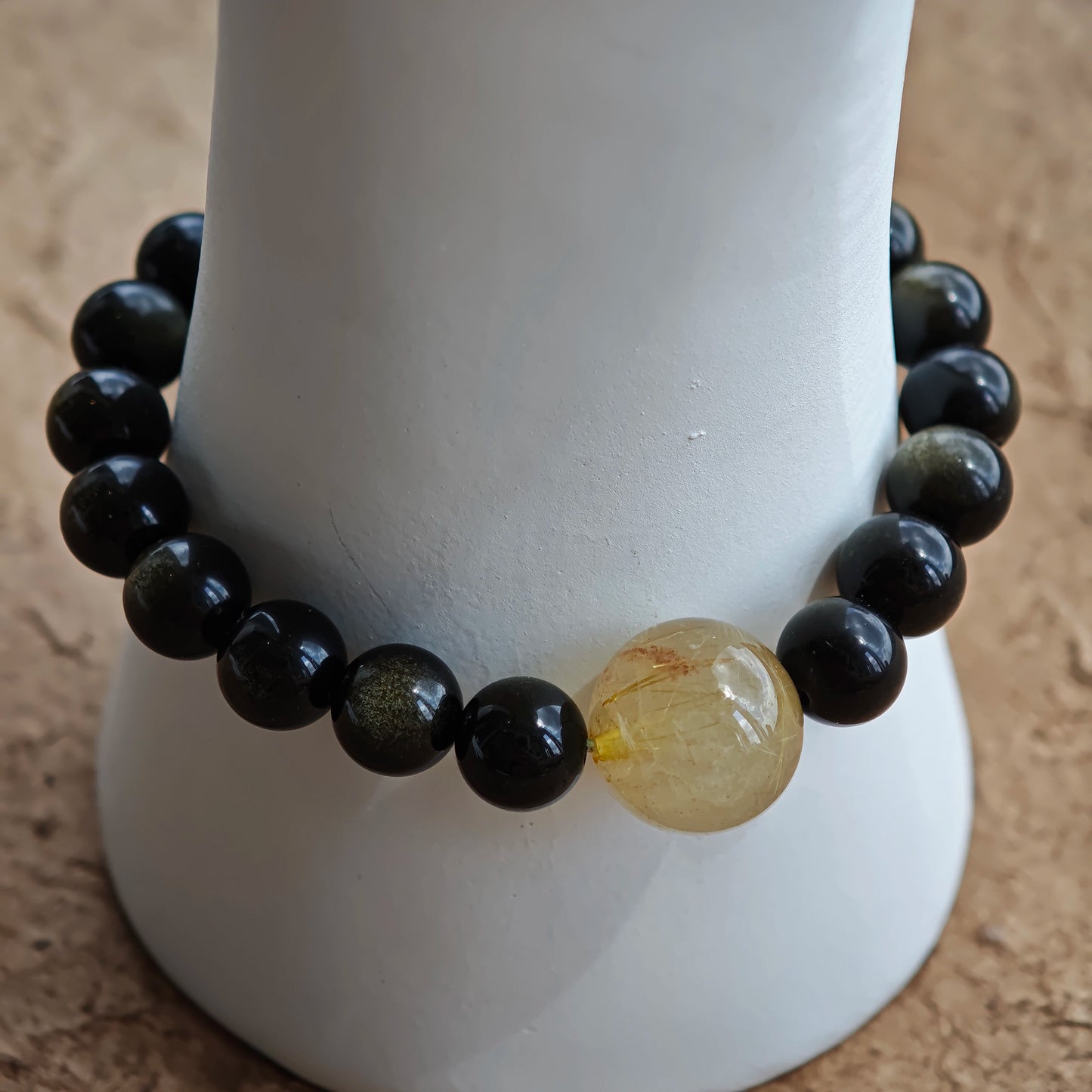 Pure obsidian beads—two tones, one purpose—partner with rutile and a sandalwood-agate pendant for cultural elegance.