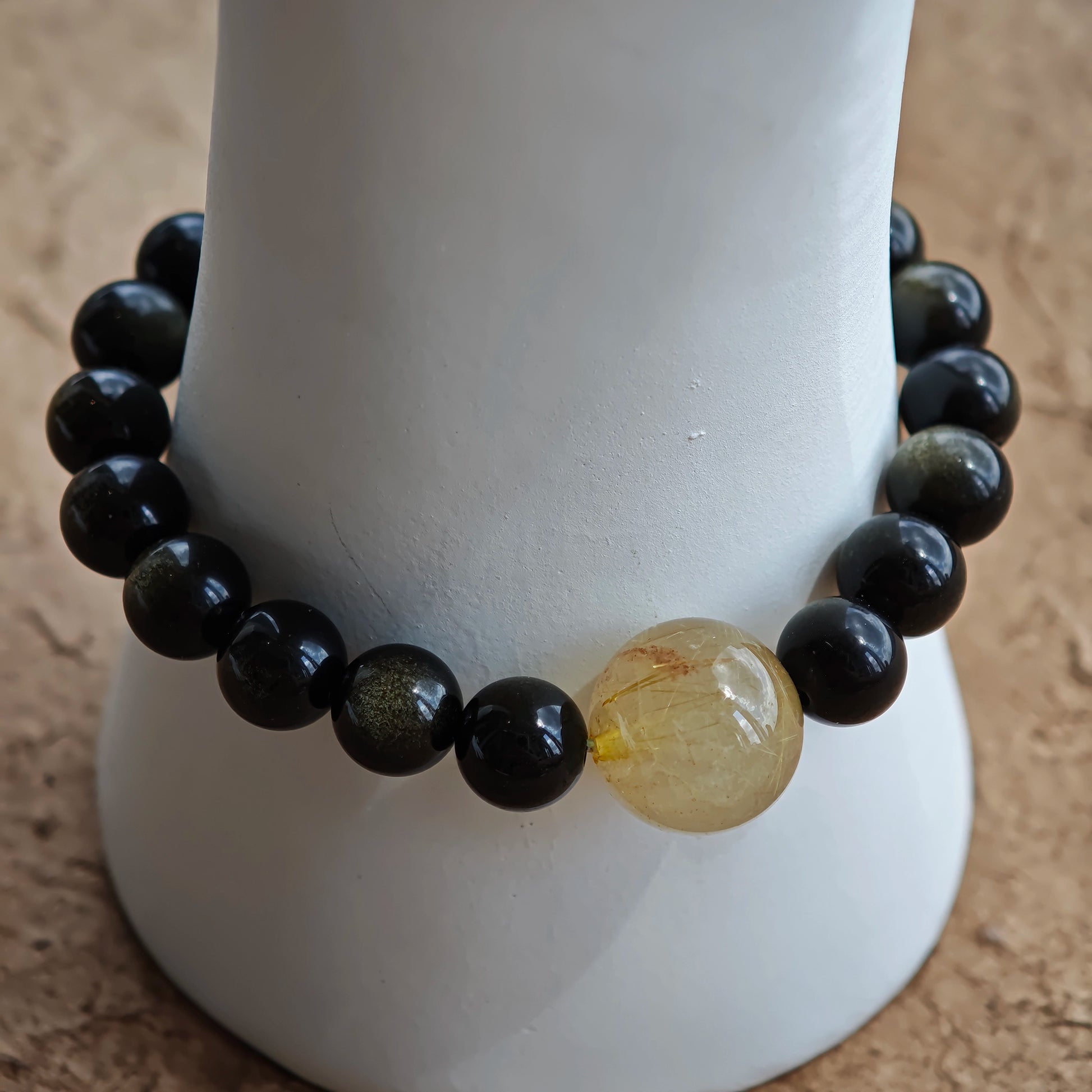 Pure obsidian beads—two tones, one purpose—partner with rutile and a sandalwood-agate pendant for cultural elegance.