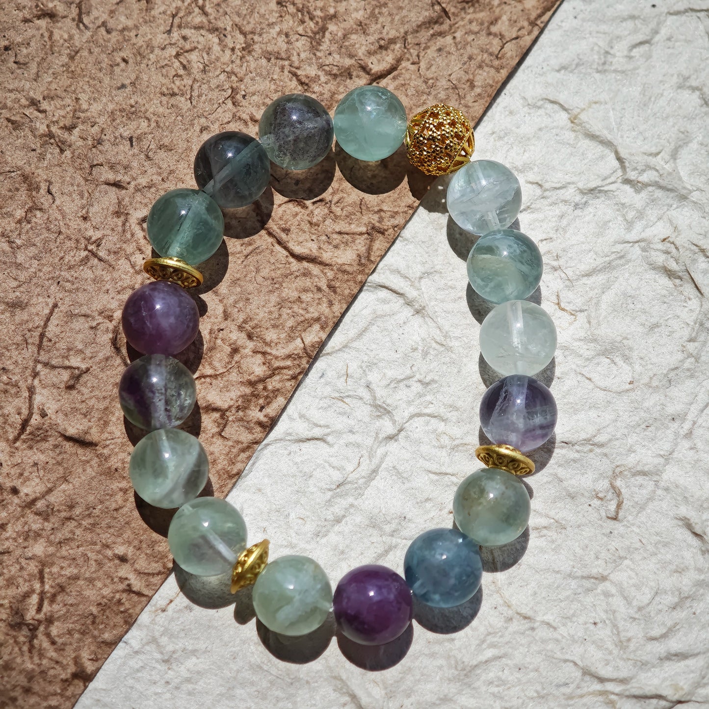 This is a natural green fluorite bracelet with gold-plated spacers. The color of each bead is different.