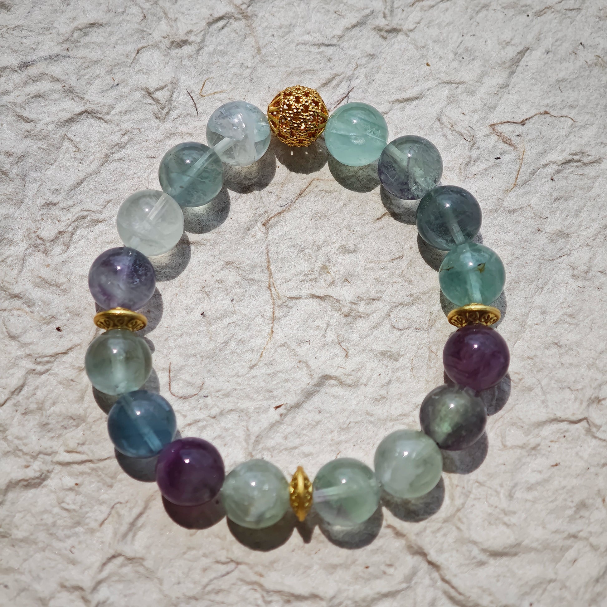 This is a natural green fluorite bracelet with gold-plated spacers. The color of each bead is different.