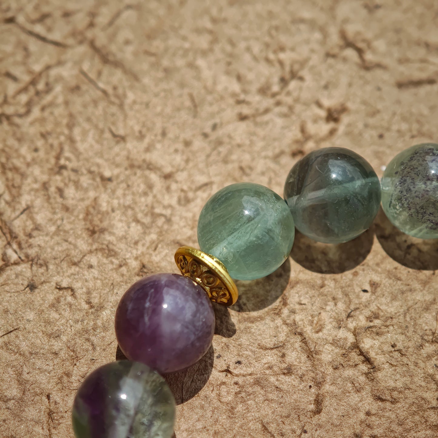 This is a natural green fluorite bracelet with gold-plated spacers. The color of each bead is different.