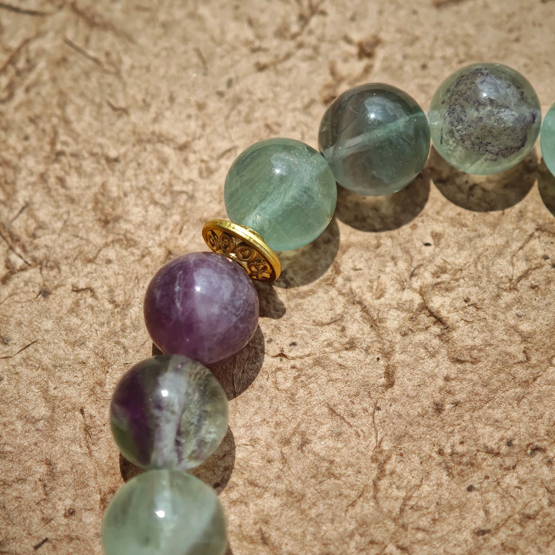 This is a natural green fluorite bracelet with gold-plated spacers. The color of each bead is different.