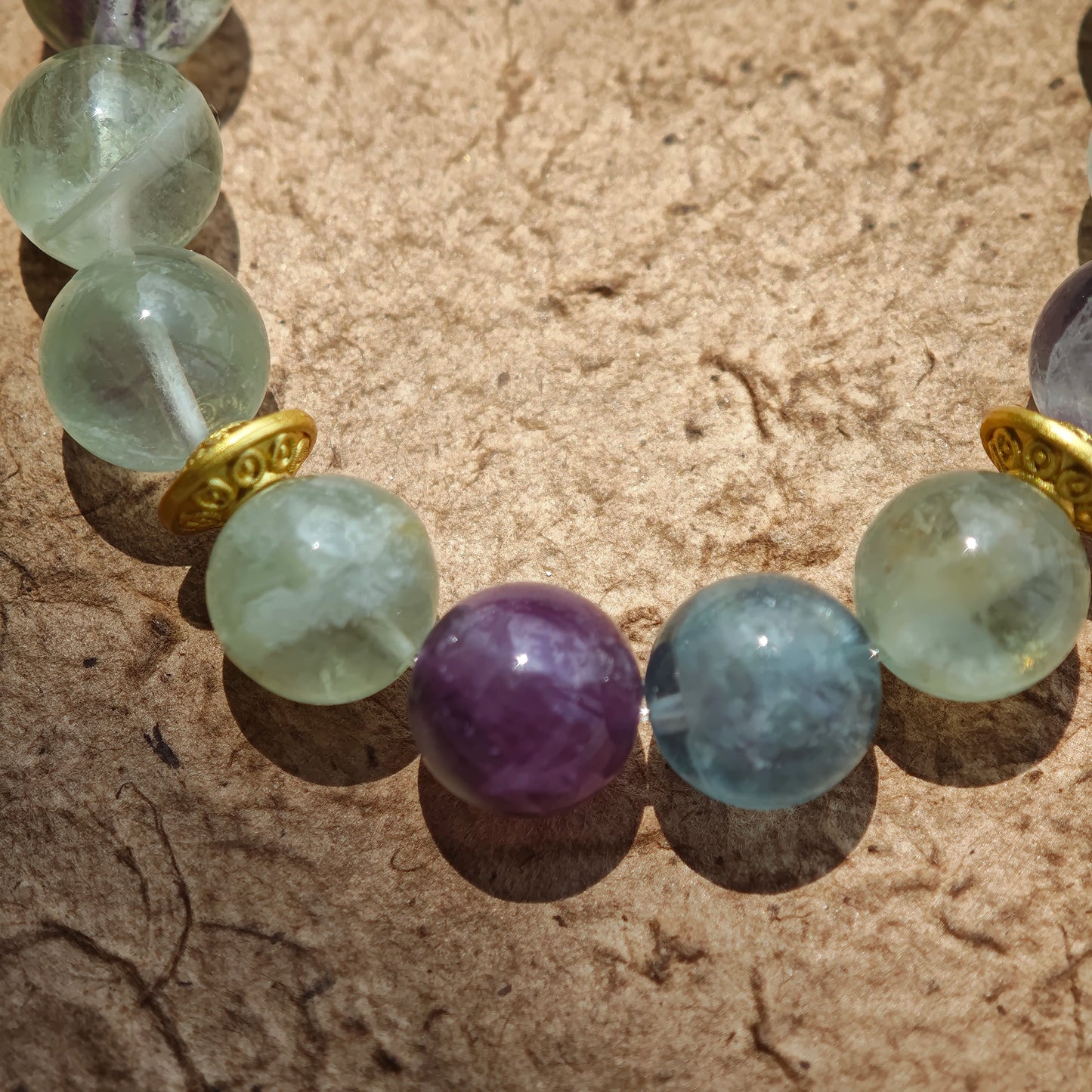 This is a natural green fluorite bracelet with gold-plated spacers. The color of each bead is different.