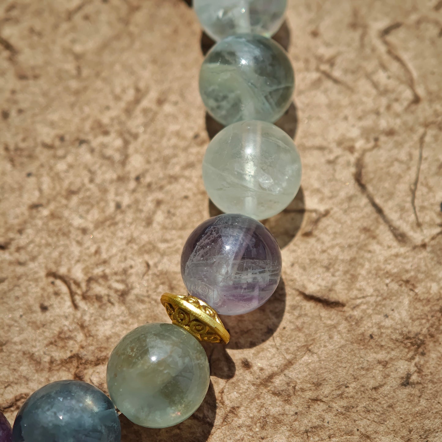 This is a natural green fluorite bracelet with gold-plated spacers. The color of each bead is different.