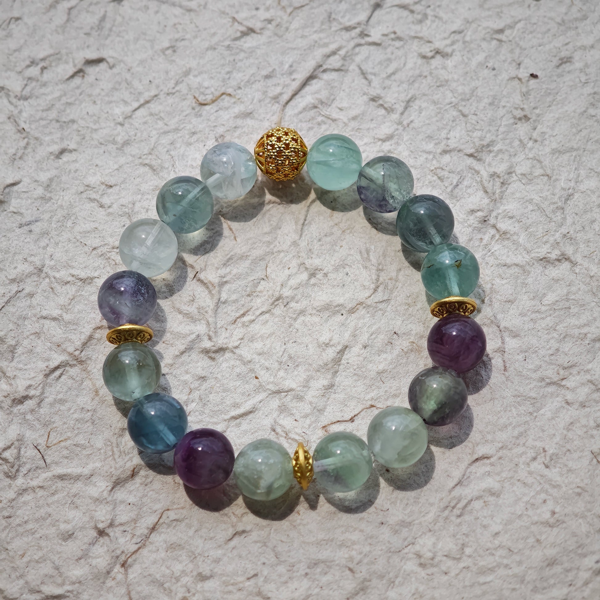 This is a natural green fluorite bracelet with gold-plated spacers. The color of each bead is different.