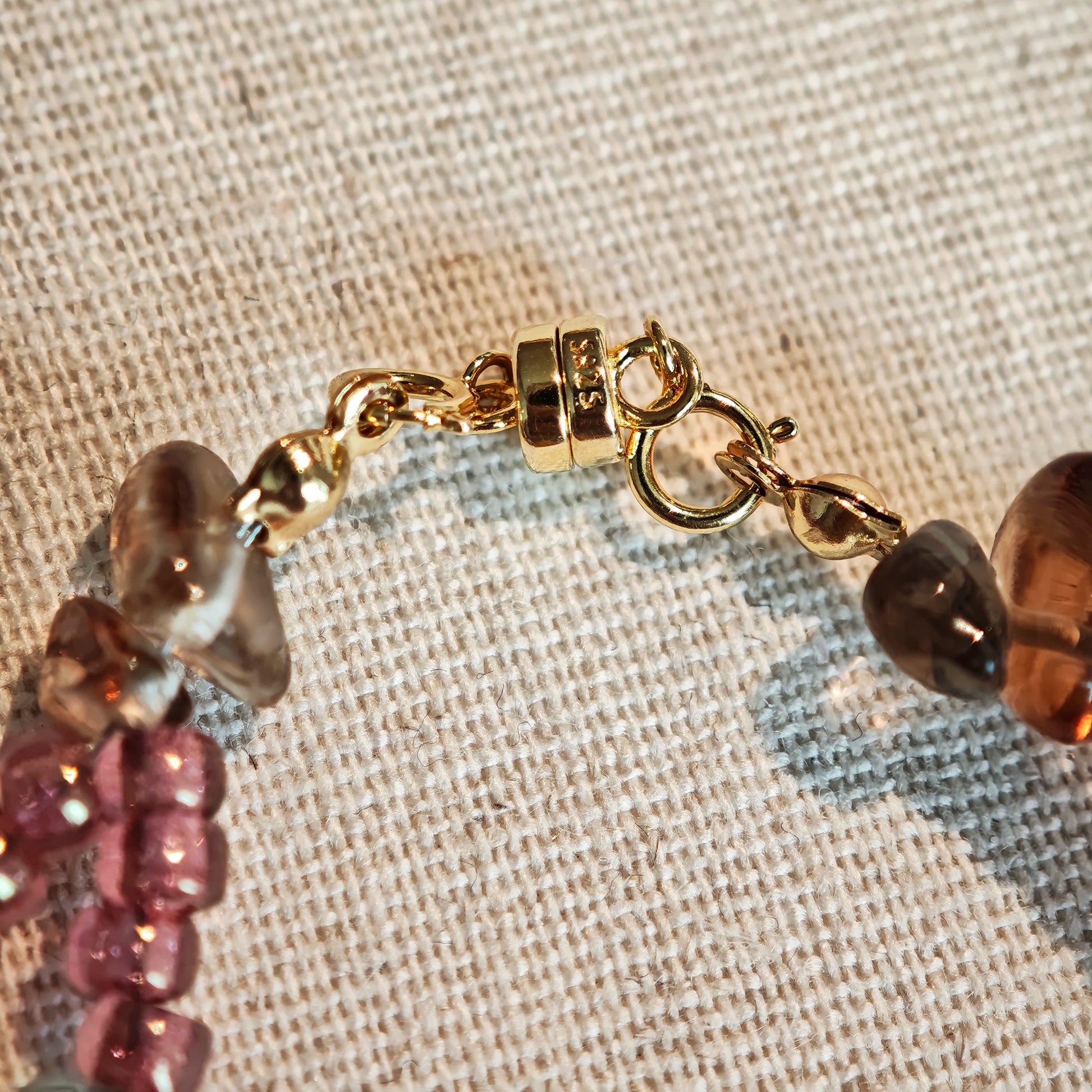 This is a pink czech beads bracelet, decorated with green leaves , yellow lemon, flowers and irregularly shape amber color beads.