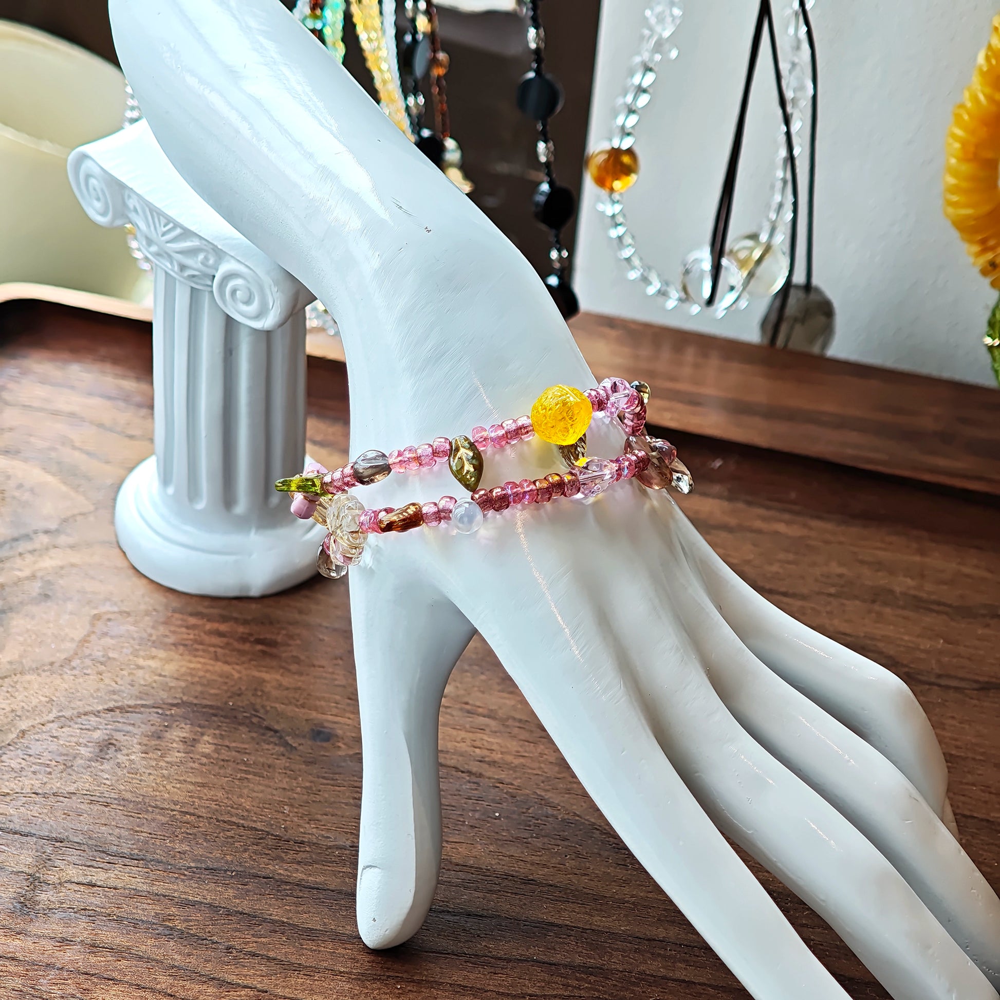 This is a pink czech beads bracelet, decorated with green leaves , yellow lemon, flowers and irregularly shape amber color beads.