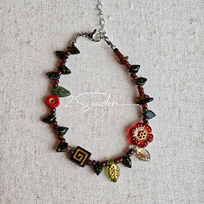This is a bracelet crafted with rich terracotta glass beads that glow like aged parchment. It captures the warmth of a late autumn sunset. In the bracelet, there are various leaves, flowers, and irregularly shaped spacers. It’s the perfect piece of vintage jewelry to add a touch of nostalgia to your daily rotation.
