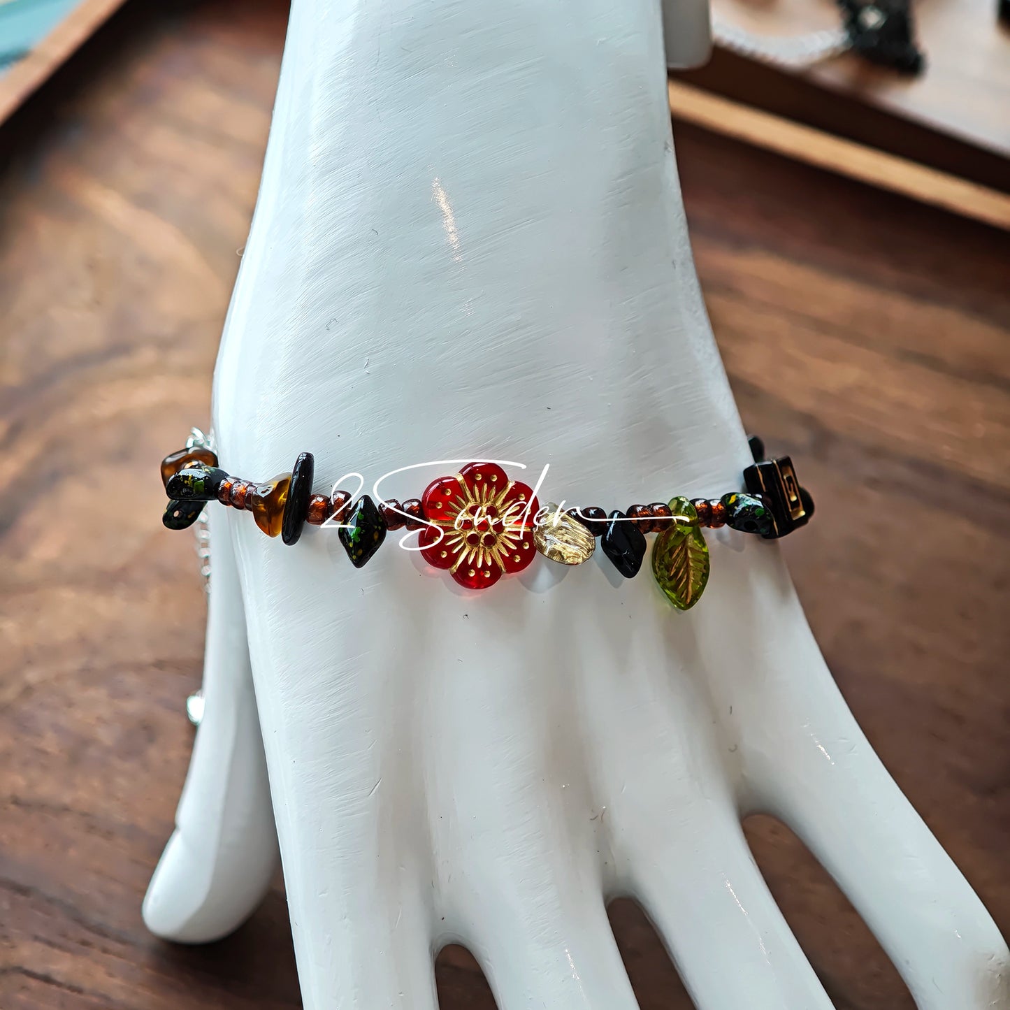 This is a bracelet crafted with rich terracotta glass beads that glow like aged parchment. It captures the warmth of a late autumn sunset. In the bracelet, there are various leaves, flowers, and irregularly shaped spacers. It’s the perfect piece of vintage jewelry to add a touch of nostalgia to your daily rotation.
