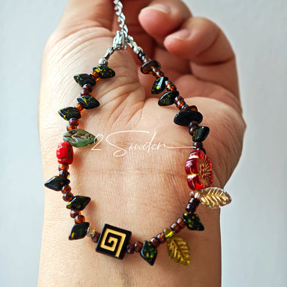 This is a bracelet crafted with rich terracotta glass beads that glow like aged parchment. It captures the warmth of a late autumn sunset. In the bracelet, there are various leaves, flowers, and irregularly shaped spacers. It’s the perfect piece of vintage jewelry to add a touch of nostalgia to your daily rotation.