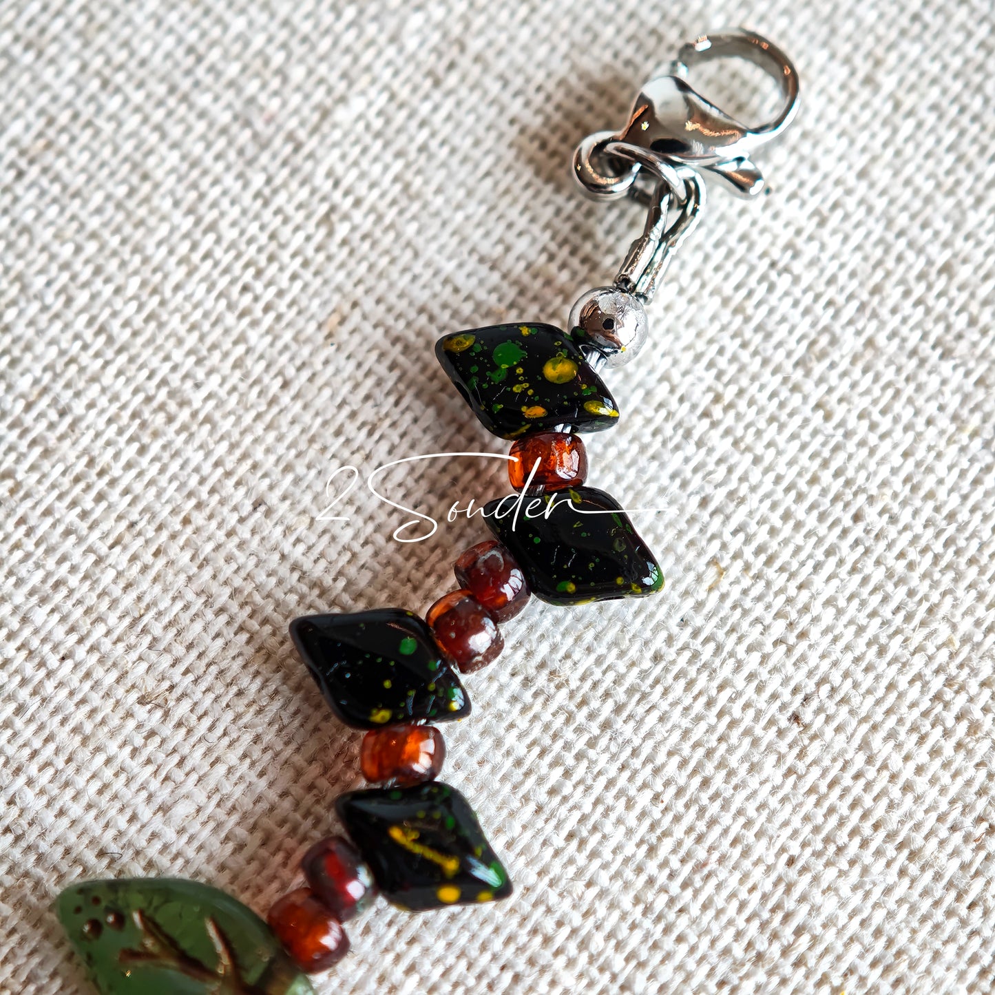 This is a bracelet crafted with rich terracotta glass beads that glow like aged parchment. It captures the warmth of a late autumn sunset. In the bracelet, there are various leaves, flowers, and irregularly shaped spacers. It’s the perfect piece of vintage jewelry to add a touch of nostalgia to your daily rotation.