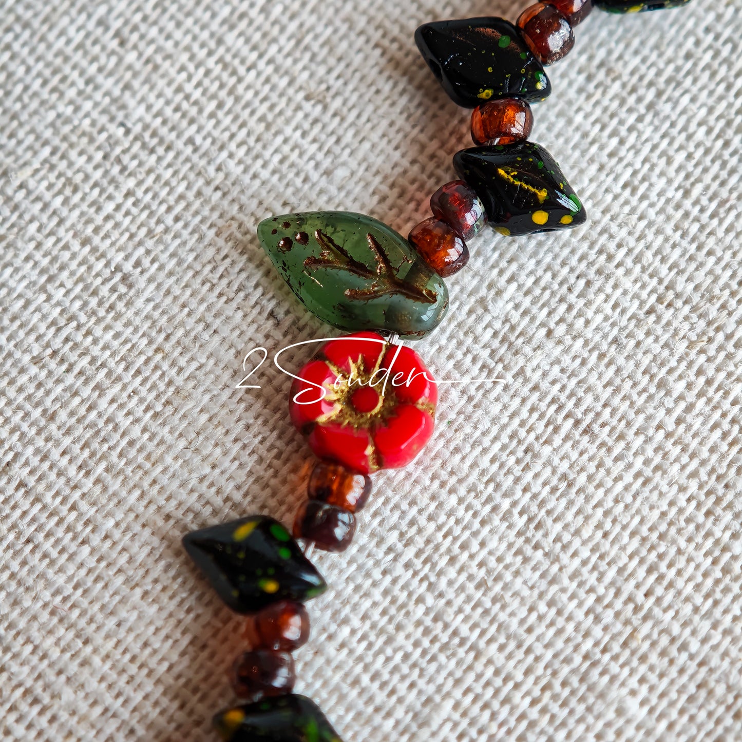 This is a bracelet crafted with rich terracotta glass beads that glow like aged parchment. It captures the warmth of a late autumn sunset. In the bracelet, there are various leaves, flowers, and irregularly shaped spacers. It’s the perfect piece of vintage jewelry to add a touch of nostalgia to your daily rotation.