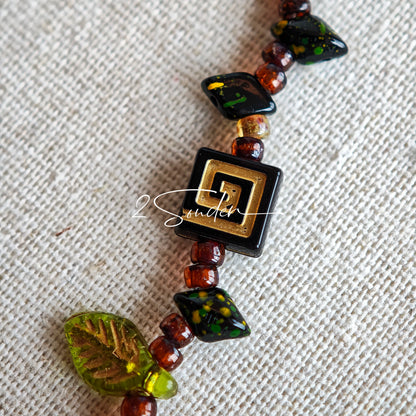 This is a bracelet crafted with rich terracotta glass beads that glow like aged parchment. It captures the warmth of a late autumn sunset. In the bracelet, there are various leaves, flowers, and irregularly shaped spacers. It’s the perfect piece of vintage jewelry to add a touch of nostalgia to your daily rotation.