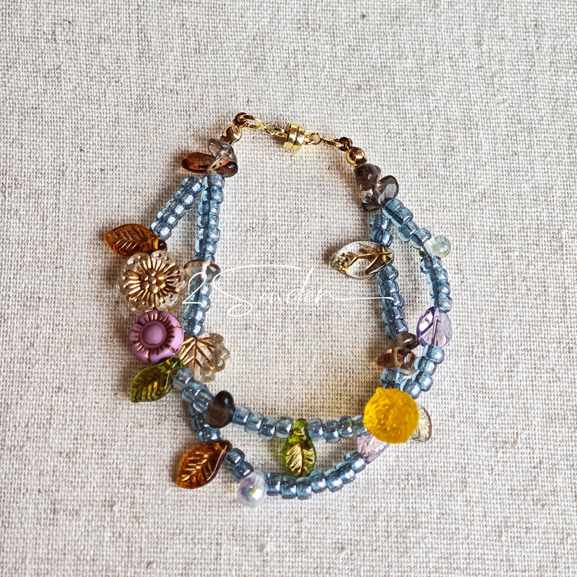 This bracelet features shimmering Czech glass beads in beautiful shades of blue, all hand-strung on a delicate double chain. An 18k gold-plated magnetic clasp makes it super easy to wear, and it's designed for a 15cm wrist.