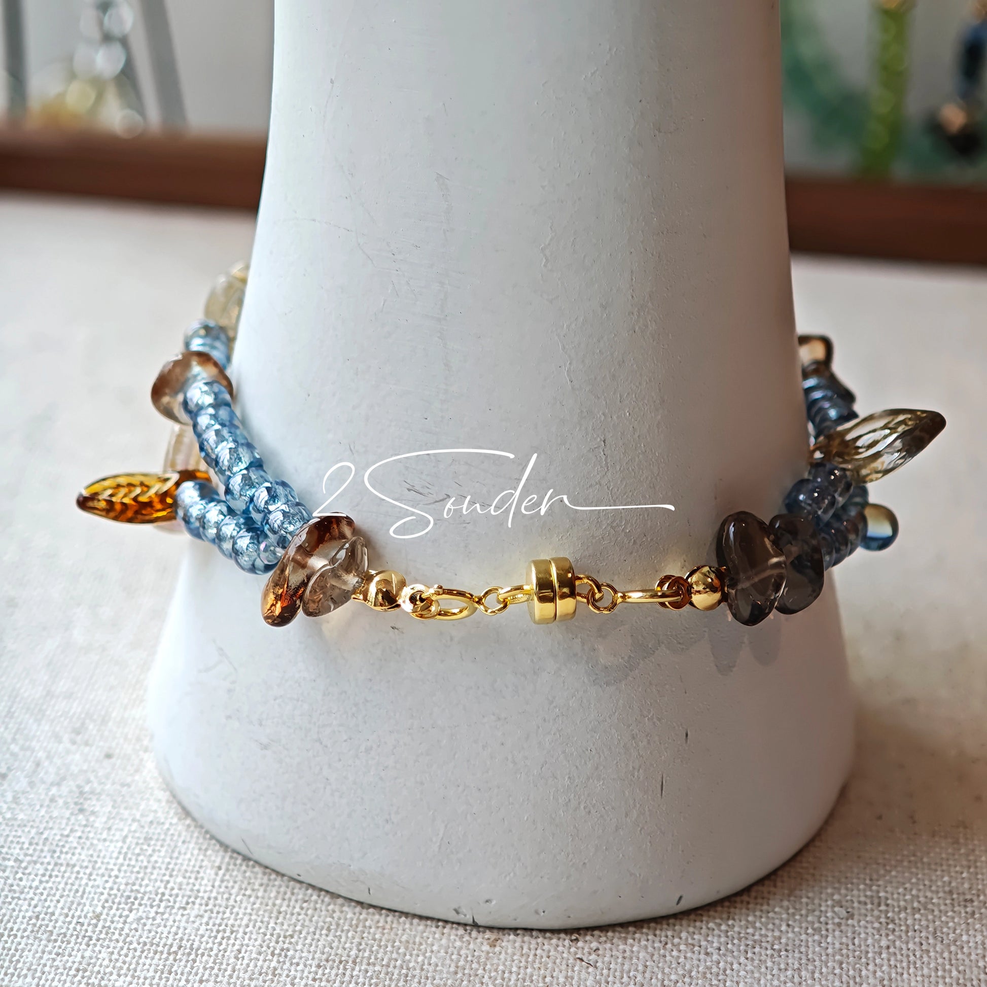This bracelet features shimmering Czech glass beads in beautiful shades of blue, all hand-strung on a delicate double chain. An 18k gold-plated magnetic clasp makes it super easy to wear, and it's designed for a 15cm wrist.