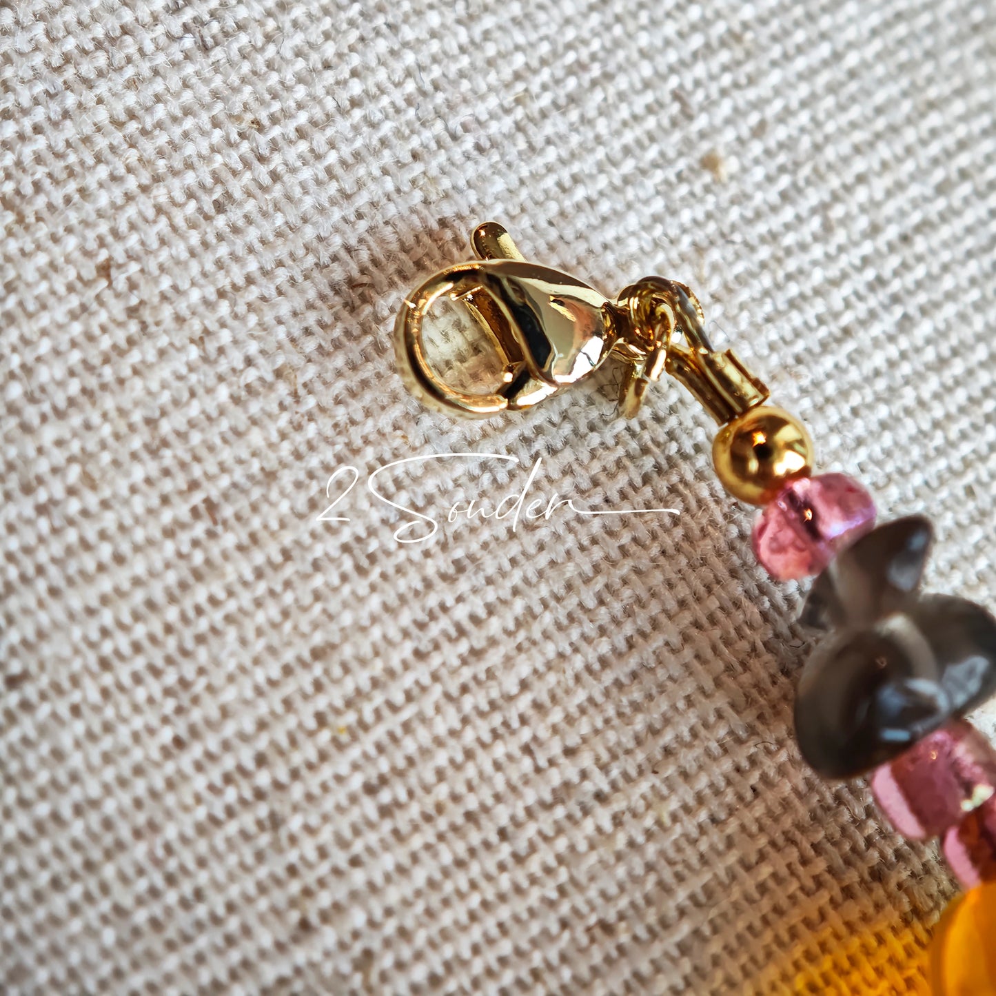 This is a bracelet consist of glass beads. The main color of the bracelet is pink. It's also decorated with orange, yellow pear, grey flower, brown leaves and green leaves spacers.