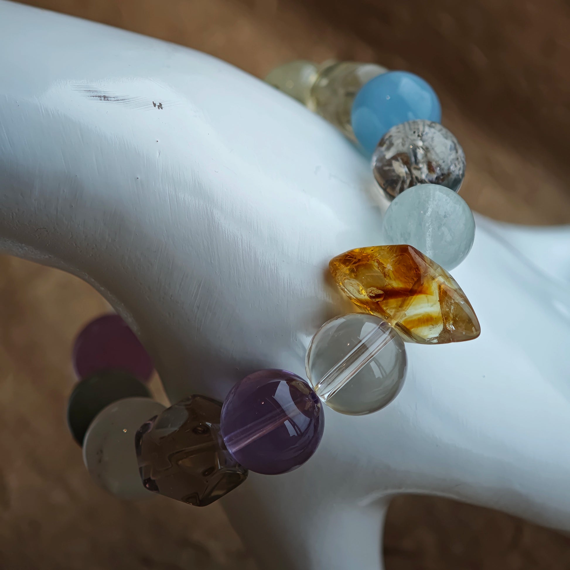 A liquid rainbow of muted pastels circles the wrist—sea, crown, sun, leaf, and cloud in concert.