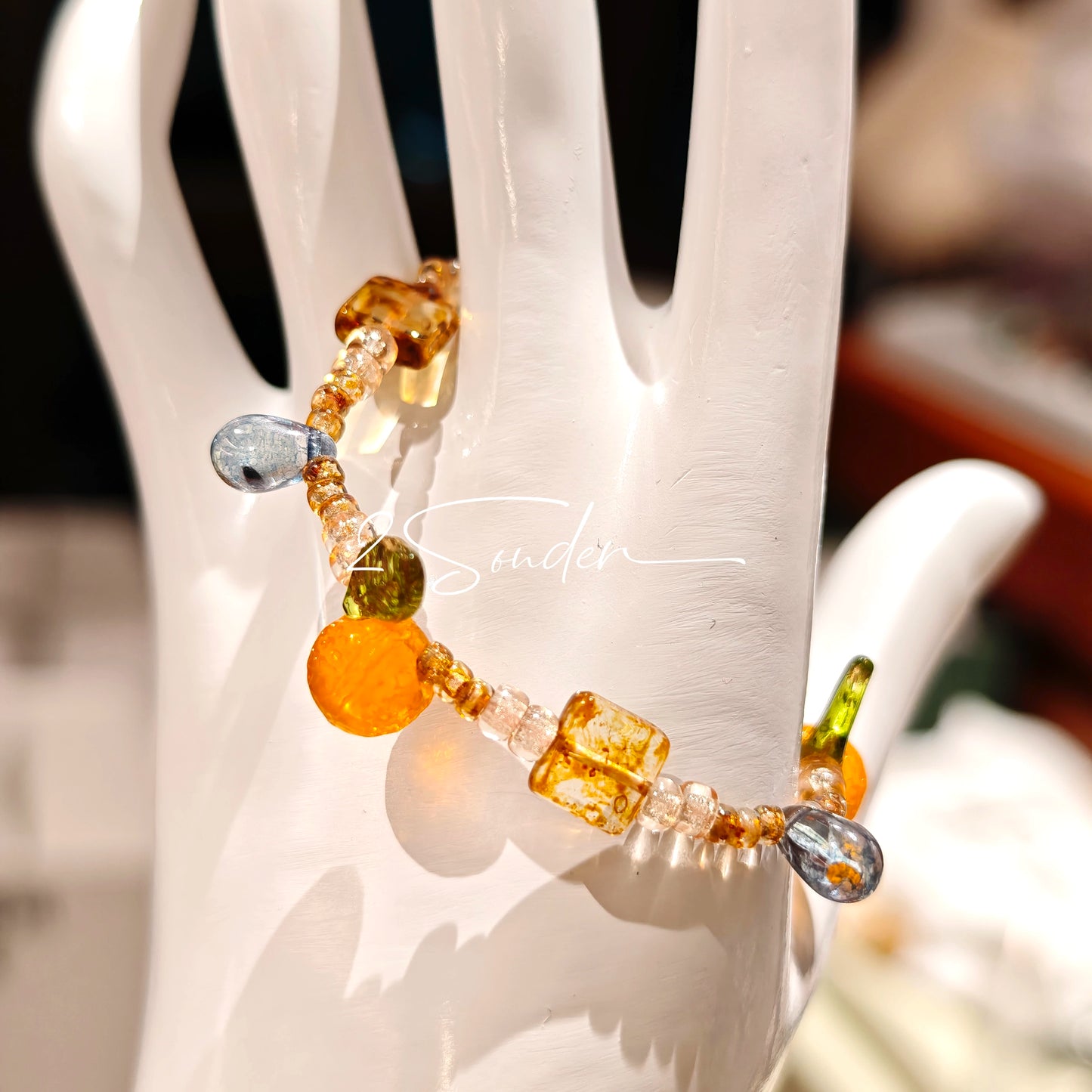 This is a bracelet made of Czech beads, orange slice spacers, leaf spacers, blue teardrop accents and elastic cord. The beads’ crystal-clear translucency catches light like dewdrops—perfect for adding a luxe touch to everyday outfits.