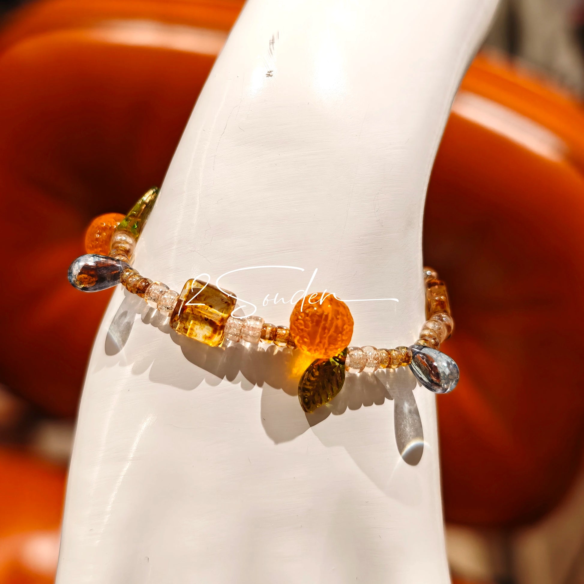This is a bracelet made of Czech beads, orange slice spacers, leaf spacers, blue teardrop accents and elastic cord. The beads’ crystal-clear translucency catches light like dewdrops—perfect for adding a luxe touch to everyday outfits.