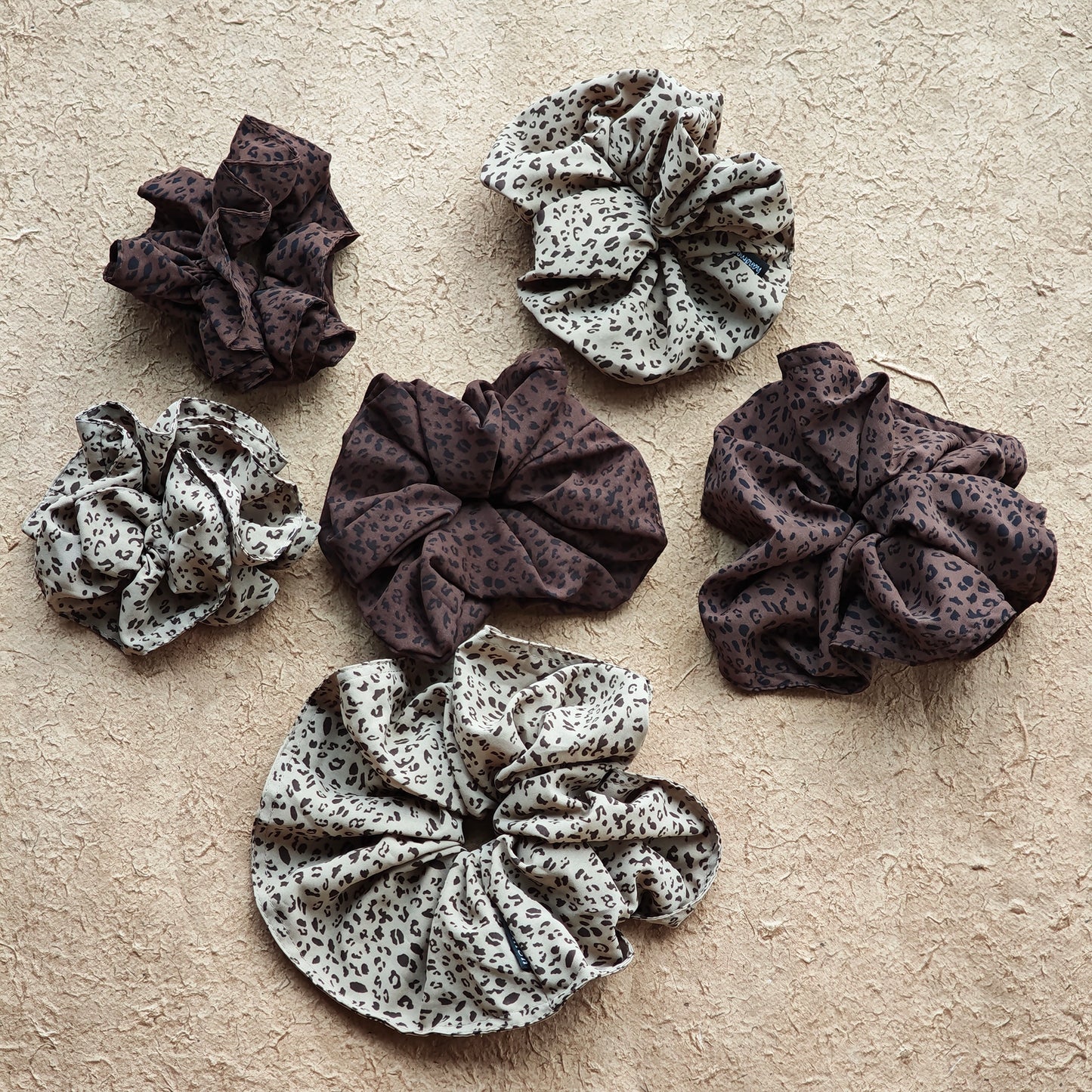 A leopard print scrunchy set with 6pcs of scrunchies, with different sizes and colors.