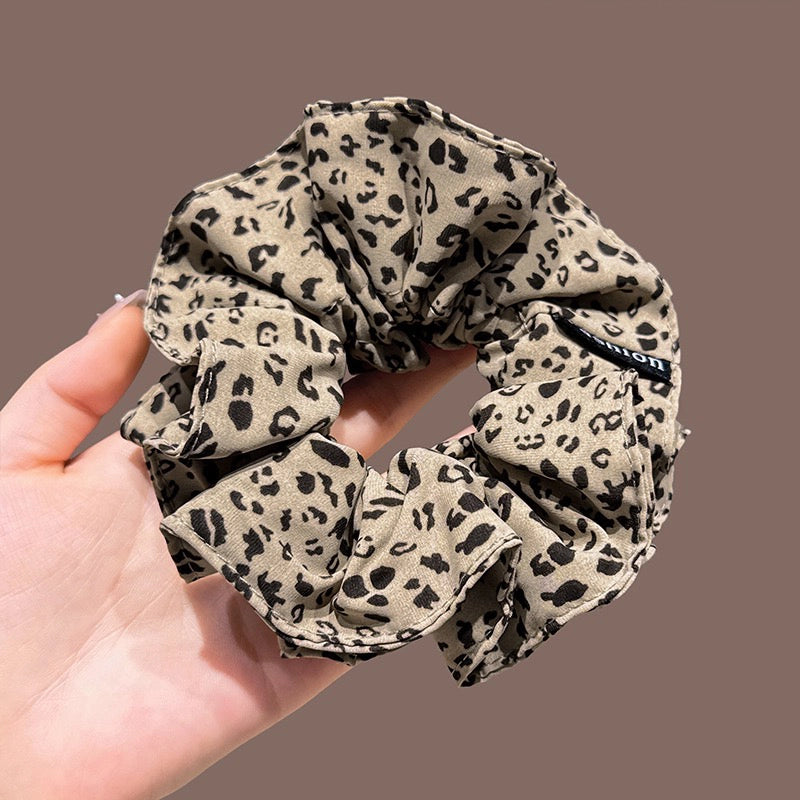 A leopard print scrunchy set with 6pcs of scrunchies, with different sizes and colors.