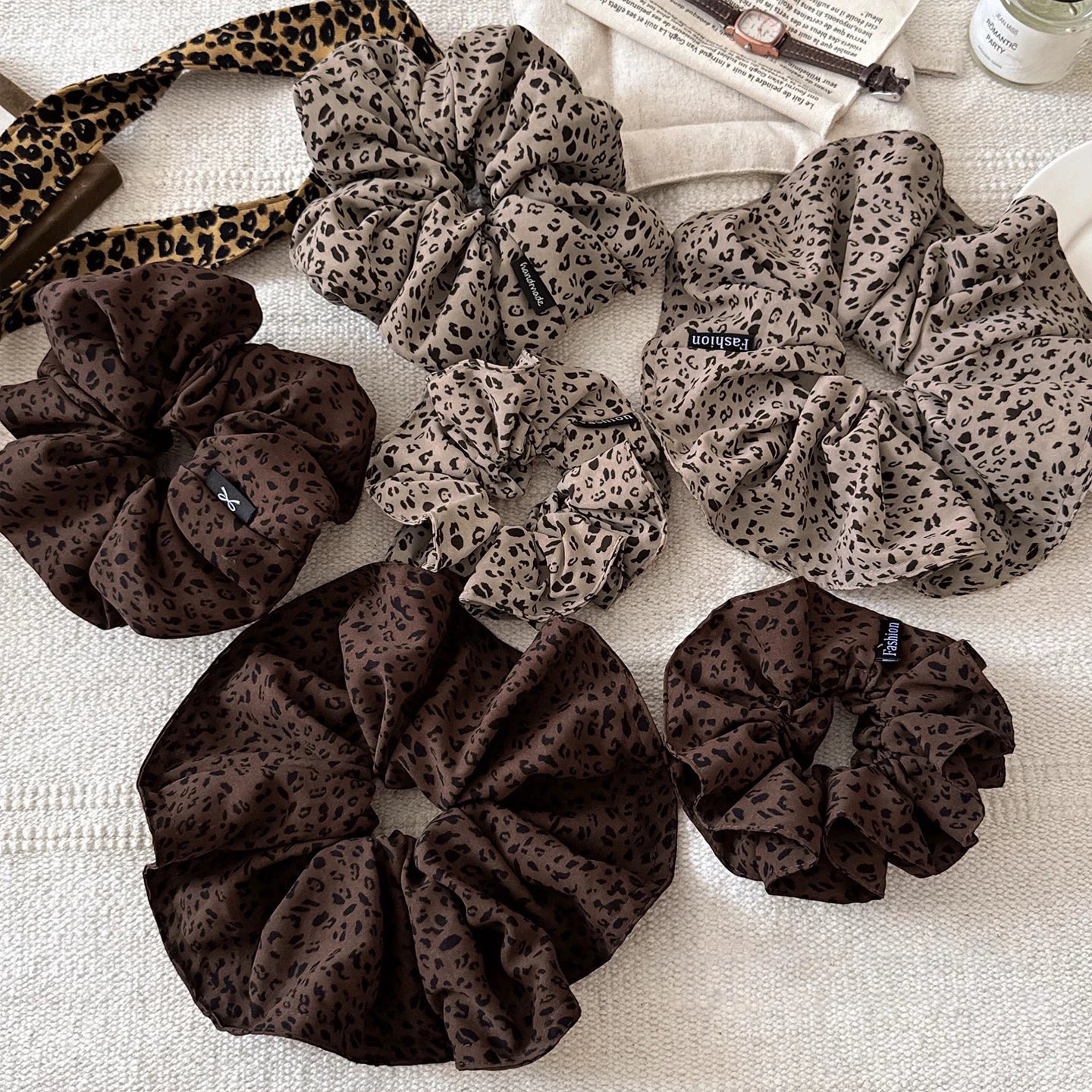 A leopard print scrunchy set with 6pcs of scrunchies, with different sizes and colors.