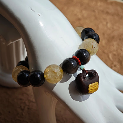 This is a silver sheen obsidian and rutilated quartz bracelet, finished with aloeswood and south red agate pendant—luxury forged in primal power.