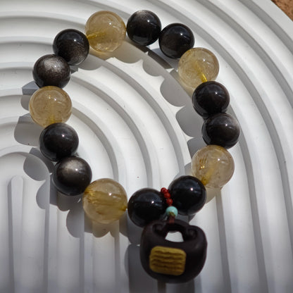 This is a silver sheen obsidian and rutilated quartz bracelet, finished with aloeswood and south red agate pendant—luxury forged in primal power.
