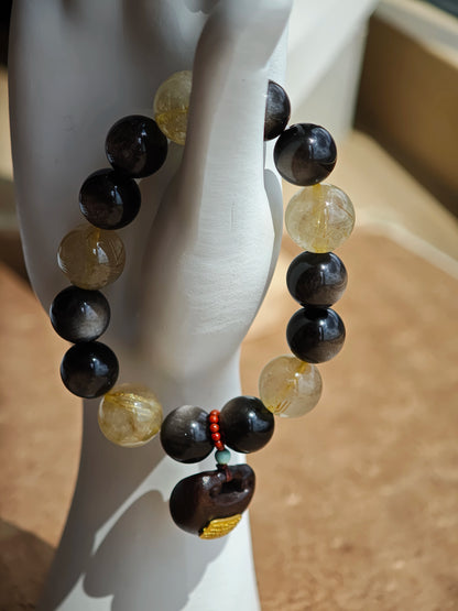 This is a silver sheen obsidian and rutilated quartz bracelet, finished with aloeswood and south red agate pendant—luxury forged in primal power.