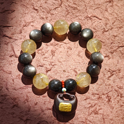This is a silver sheen obsidian and rutilated quartz bracelet, finished with aloeswood and south red agate pendant—luxury forged in primal power.
