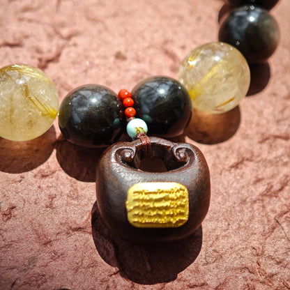 This is a silver sheen obsidian and rutilated quartz bracelet, finished with aloeswood and south red agate pendant—luxury forged in primal power.