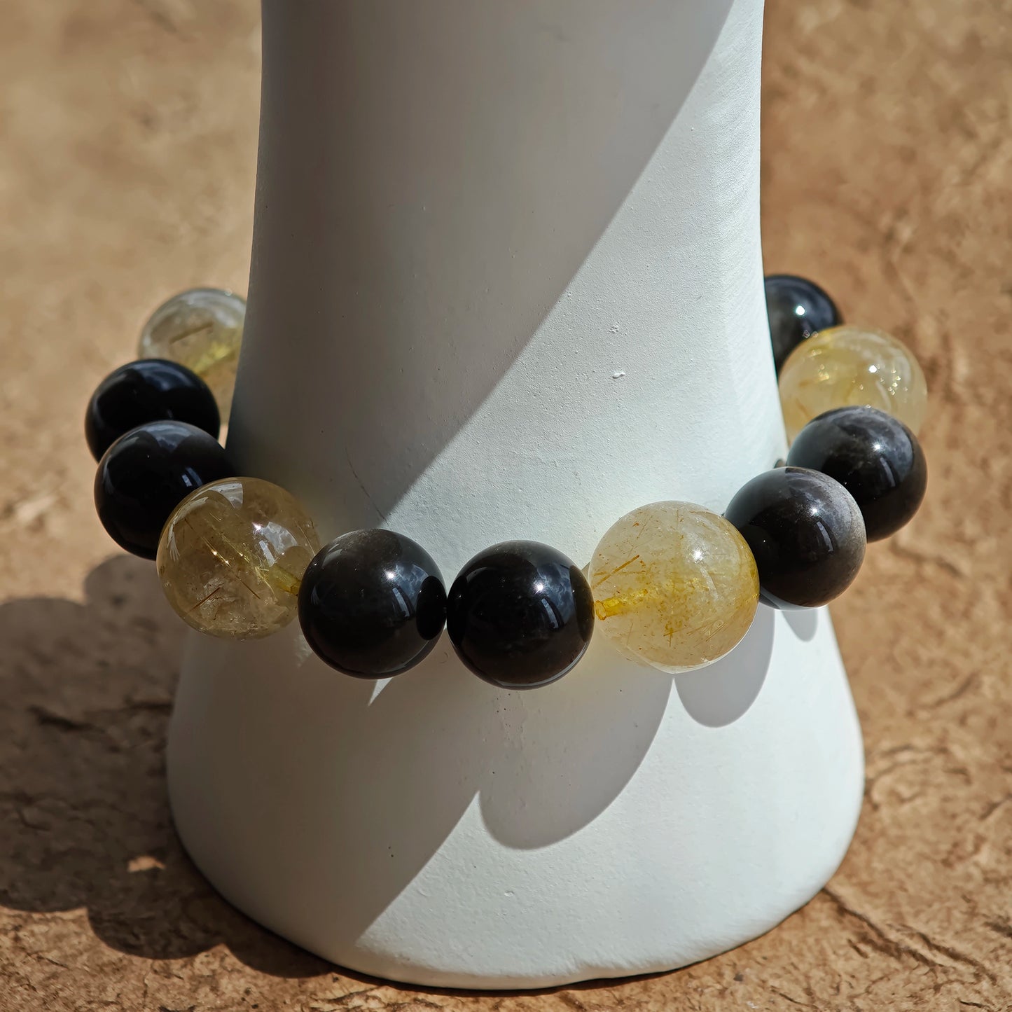 This is a silver sheen obsidian and rutilated quartz bracelet, finished with aloeswood and south red agate pendant—luxury forged in primal power.