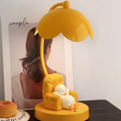 This is a bedside lamp with a design of a duck lying in a yellow sofa. And it comes with a round lampshade. Smooth rounded lines and artistic detailing make it a decorative bedside lamp and a comforting companion after long workdays.