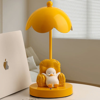 This is a bedside lamp with a design of a duck lying in a yellow sofa. And it comes with a round lampshade. Smooth rounded lines and artistic detailing make it a decorative bedside lamp and a comforting companion after long workdays.