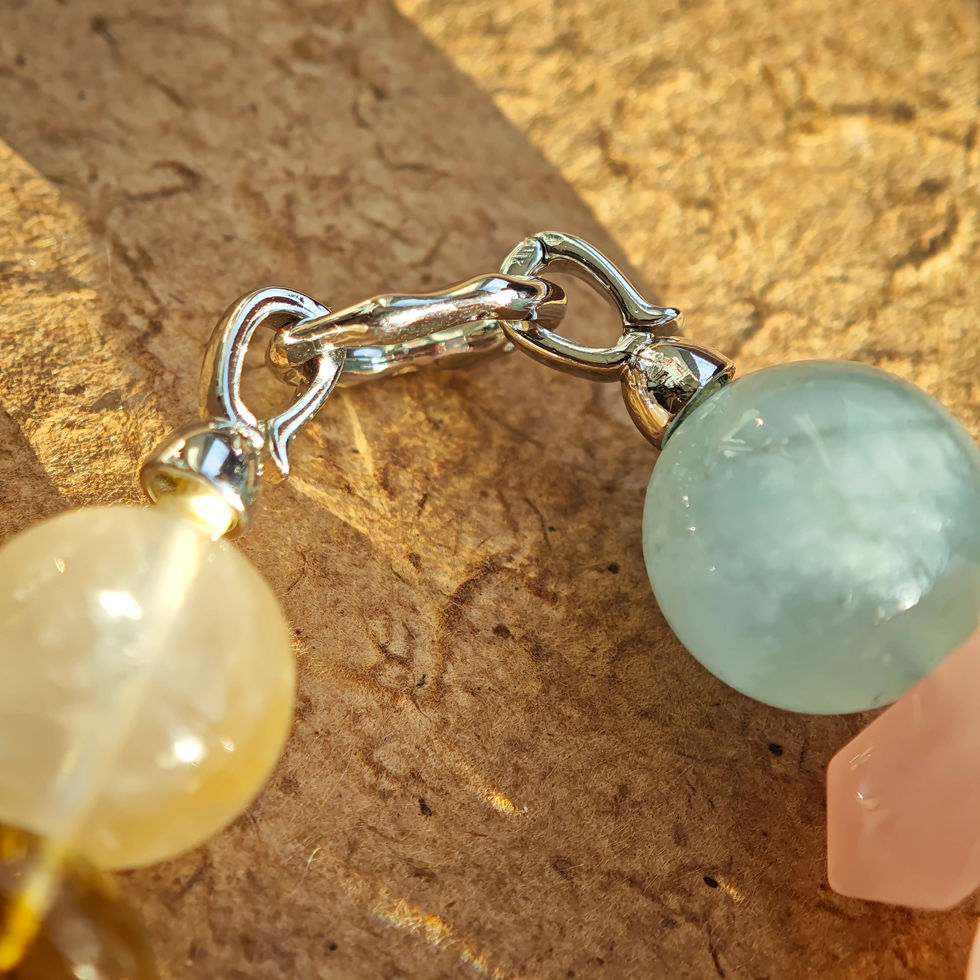 The bracelet blends sea-green aquamarine, rosy quartz, icy clear quartz, golden citrine, and purple amethyst.
