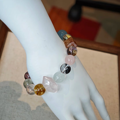 This multi gemstone bracelet features aquamarine, amethyst, strawberry quartz, rose quartz, green phantom quartz, and black rutilated quartz.