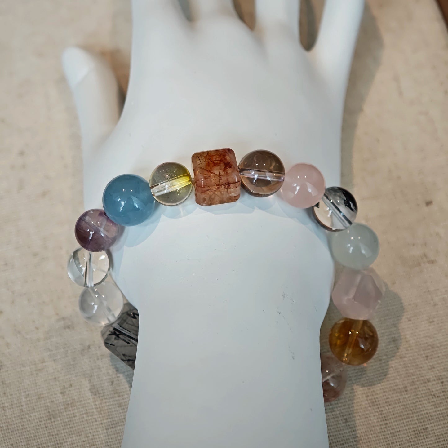 This multi gemstone bracelet features aquamarine, amethyst, strawberry quartz, rose quartz, green phantom quartz, and black rutilated quartz.