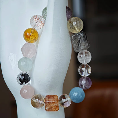 This multi gemstone bracelet features aquamarine, amethyst, strawberry quartz, rose quartz, green phantom quartz, and black rutilated quartz.