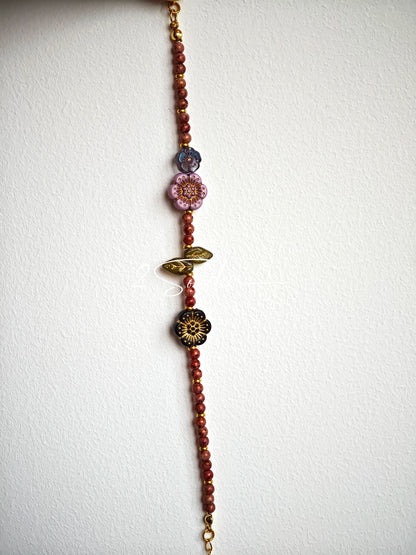 This is a bracelet that made of Czech beads. And it's highlighted by blue, purple, and black flower charms and green leaf accents, creating a stunningly attractive design.