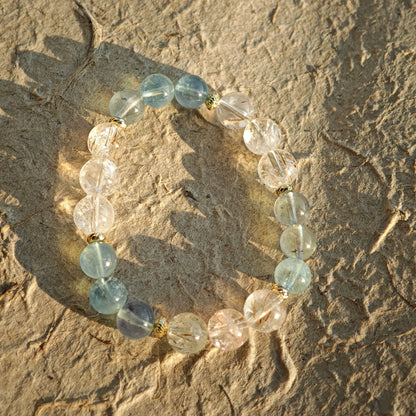 The strand blends oceanic blue and golden light, edged in understated gold elegance.