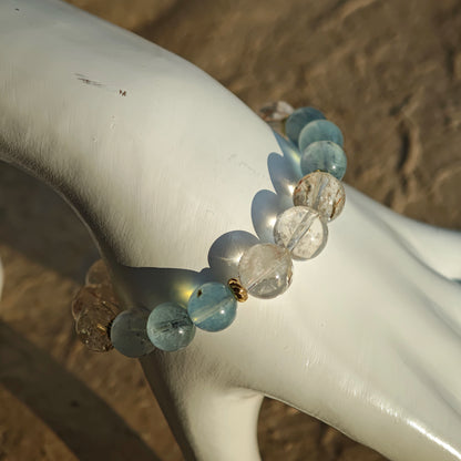 Aquamarine crystals and rutile needles glide through gilded intervals, like sunlight on surf.