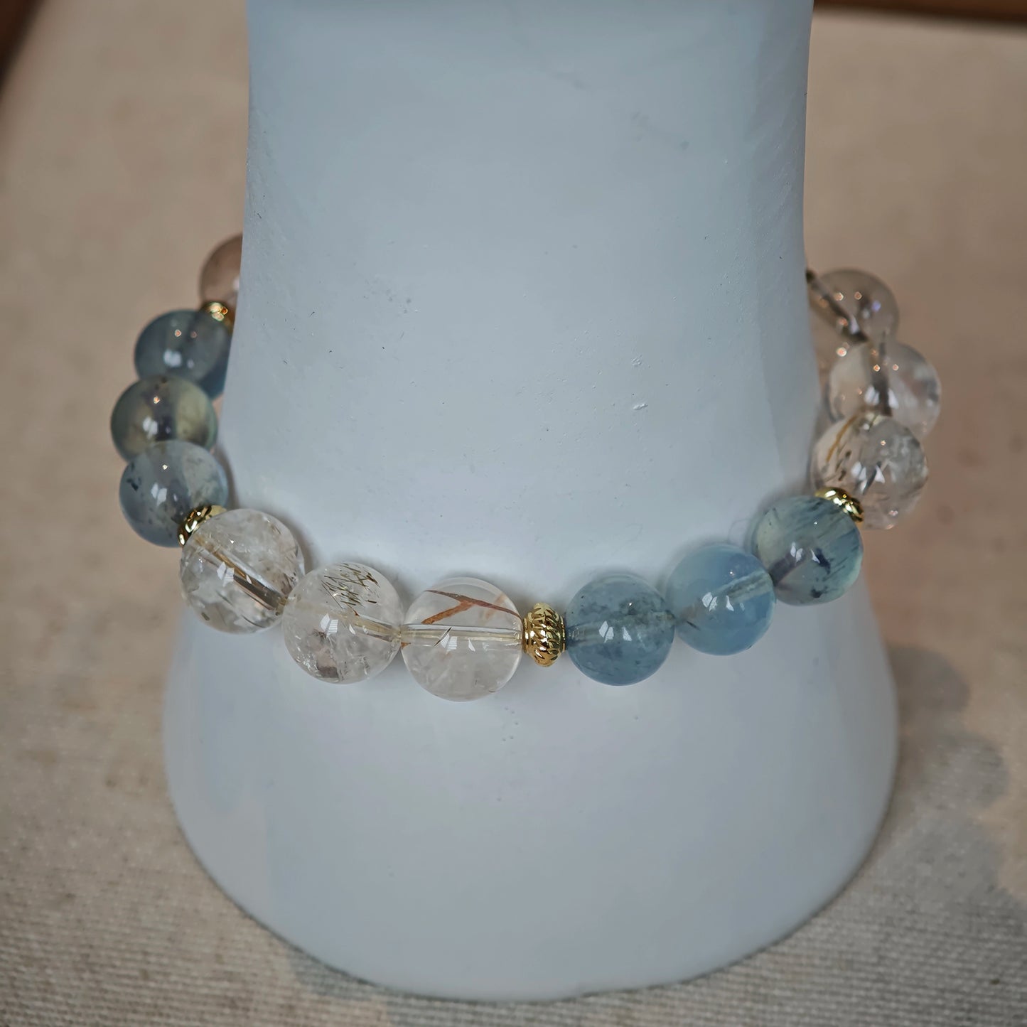 Each aquamarine bead is a wave, each rutile bead a sunbeam, bound by gilded shores.