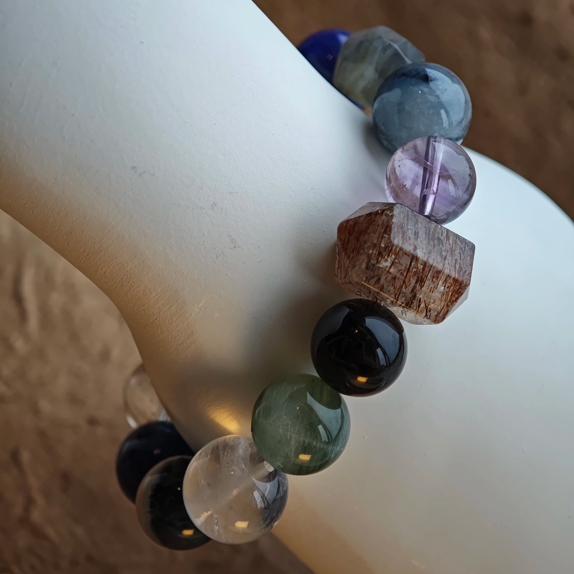 Subtle graphite blues shimmer through Black Gold Super Seven, Herkimer diamonds, clear quartz, sandalwood, amethyst, silver obsidian, white phantom, and kyanite.