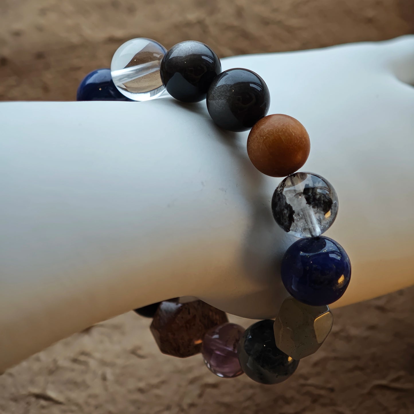 Veiled in storm-cloud colors, the bracelet marries Black Gold Super Seven, Herkimer diamonds, clear quartz, sandalwood, amethyst, silver obsidian, white phantom quartz, and kyanite.