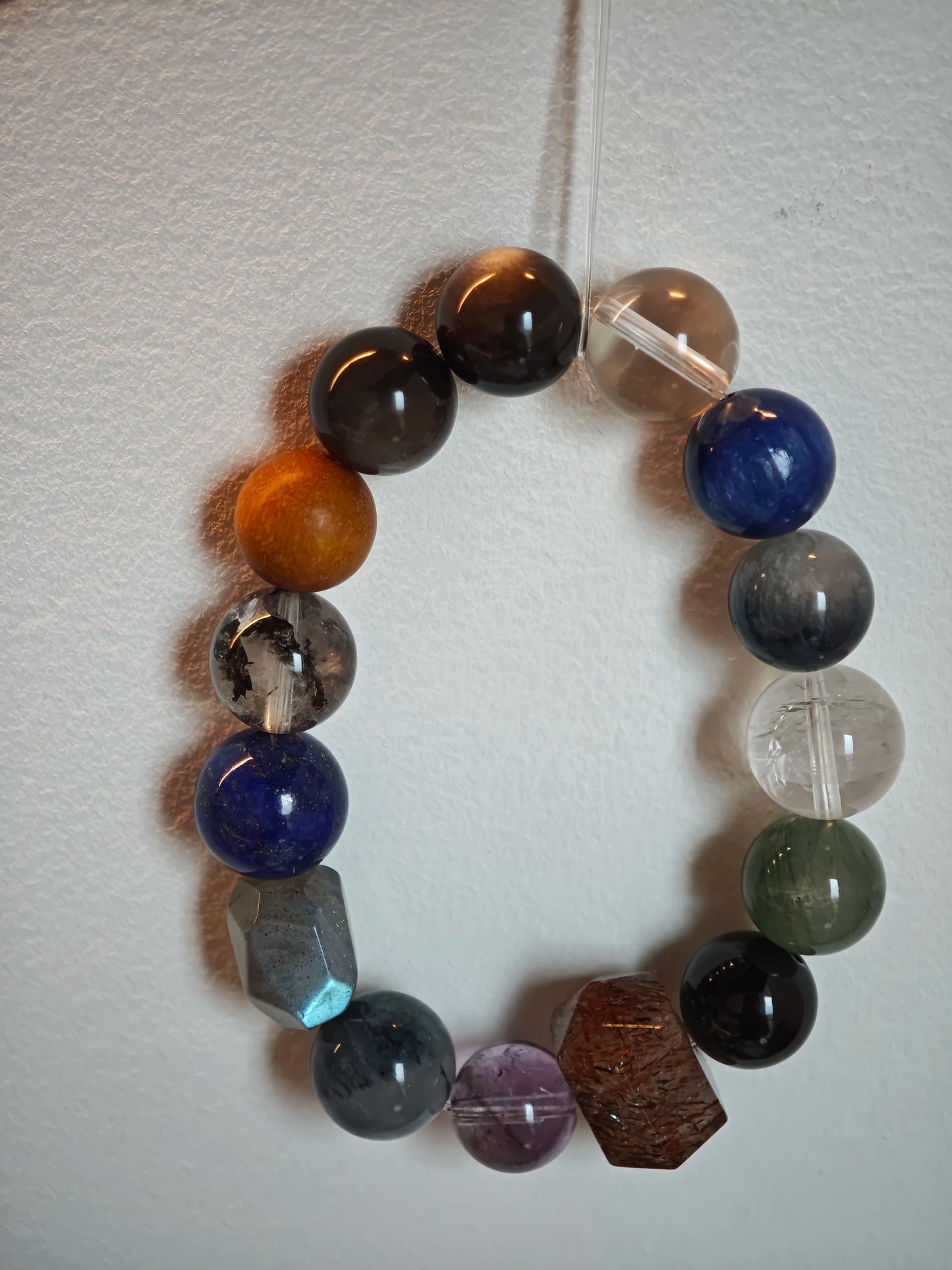 Moonlit steel and midnight surf color this bracelet of Black Gold Super Seven, Herkimer diamonds, clear quartz, sandalwood, amethyst, silver obsidian, white phantom quartz, and kyanite.