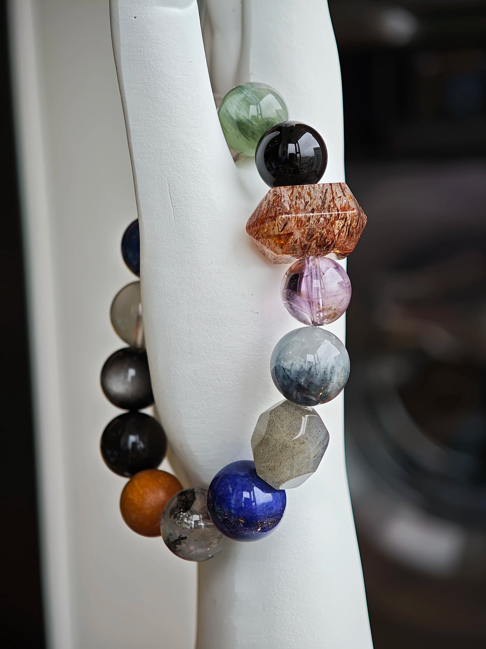 Wrapped in smoky indigo, the bracelet gathers Black Gold Super Seven, Herkimer diamonds, clear quartz, sandalwood, amethyst, silver obsidian, white phantom, and kyanite.