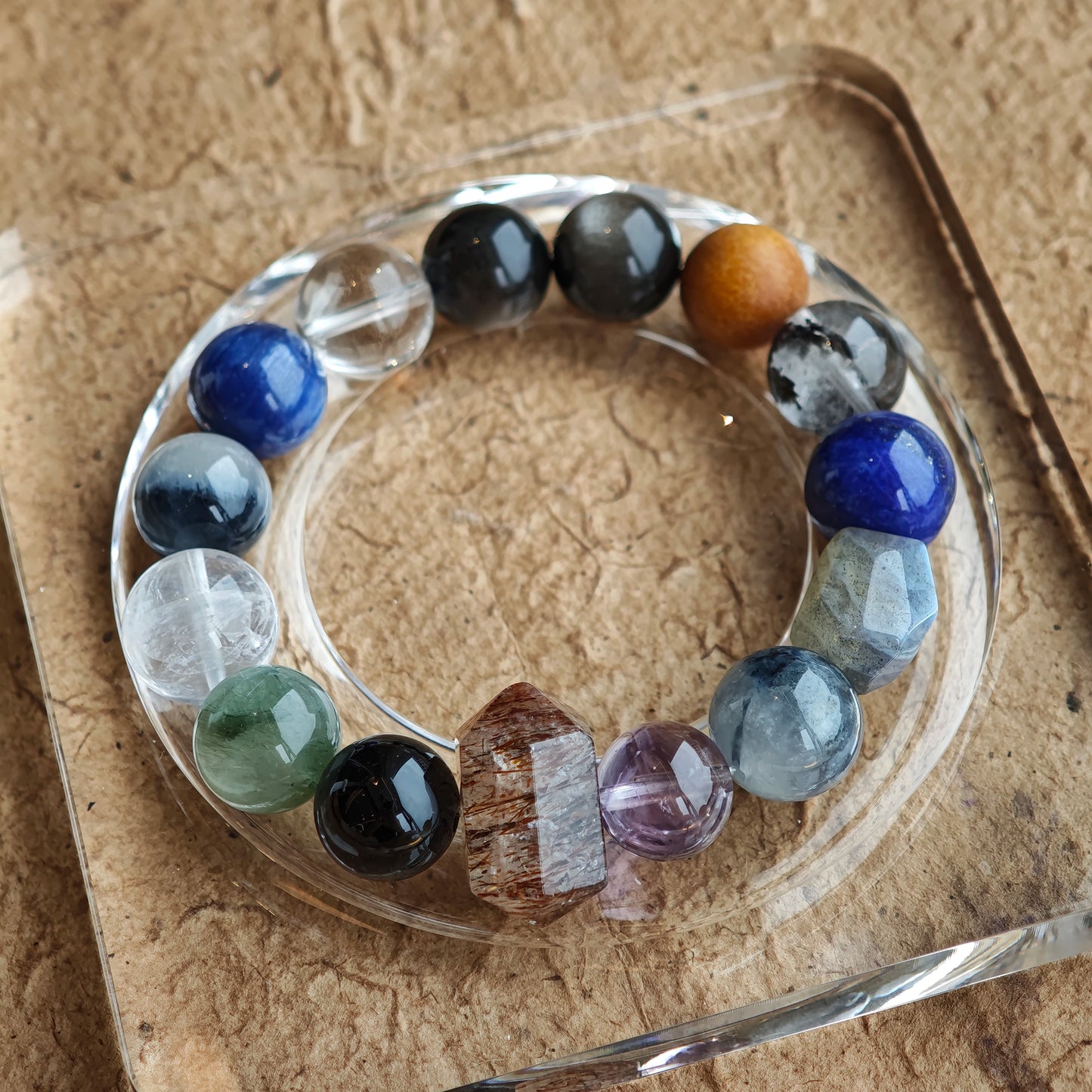 A brooding blue-grey spectrum pulses through Black Gold Super Seven, Herkimer diamonds, clear quartz, sandalwood, amethyst, silver obsidian, white phantom, and kyanite.